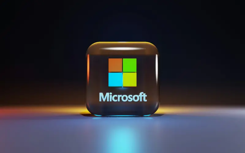 3D Microsoft logo cube with glass effect and vibrant reflections on a dark background