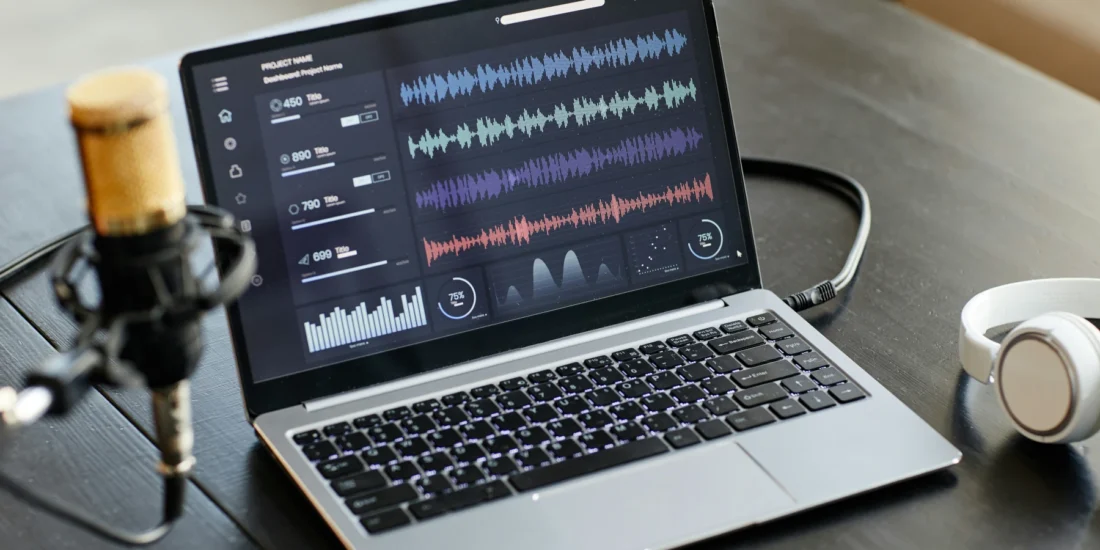 Laptop Displaying Audio Waveforms Beside Microphone And Headphones Representing Cd To Mp3 Conversion Denver Services.