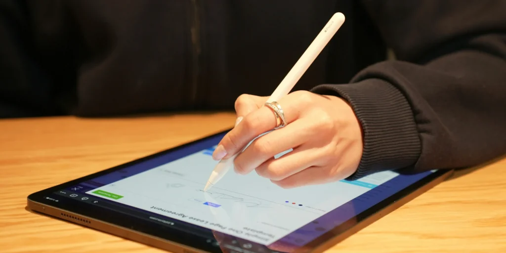 A Tst Managed It Services Denver Employee Signing A Document On A Tablet Using A Stylus.