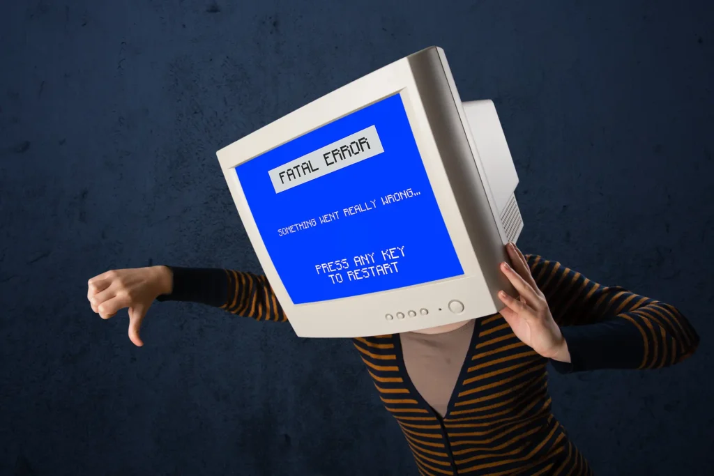 What Microsoft'S Windows 10 Esu Extension Actually Means For Your Business 3 Frustrated Computer User Wearing A Crt Monitor Displaying A Fatal Error, Representing Windows 10 Esu Extension Support And System Issues.