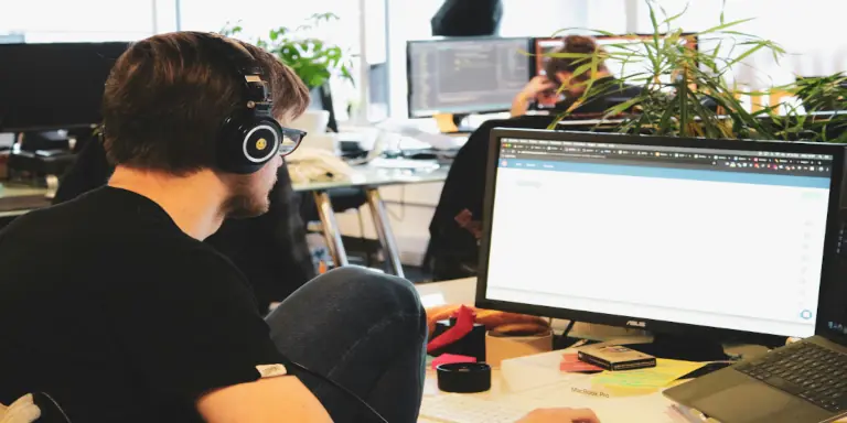 Helpdesk technician assisting with IT support questions in a modern office