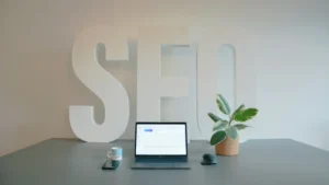 Seo Strategy Workspace With Laptop Showing Analytics In Front Of Large Seo Letters