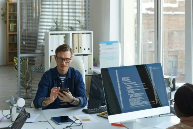 Managed Web Solutions Team Collaborating In A Bright Office Working On Website Design, Hosting, And Optimization