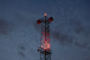 Communication Tower Glowing Red Lights Against Night Sky
